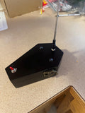 May include: A black coffin-shaped box with a silver antenna extending from the top. The box has a small red switch on the side and a decorative metal clasp on the front.