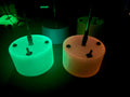 May include: Three round, white, glowing objects with black accents. The objects are lit from within, with one glowing green, one glowing orange, and one glowing blue.
